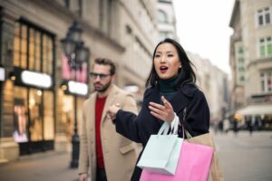 Woman in Black Coat Holding Paper Bags